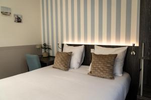a bed with white sheets and pillows in a room at Het Hart van Weesp in Weesp