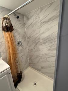a shower with a tan shower curtain in a bathroom at Island Motor Inn in Island Park