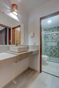 Un baño con lavabo, espejo y ducha. en HS Residence 1, en Itacaré 29 fotos más