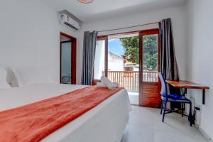 Un dormitorio con una cama y un escritorio y una ventana. en HS Residence 1, en Itacaré