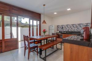 cocina con mesa de madera, sillas y encimera en HS Residence 1, en Itacaré