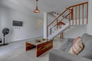 Una sala de estar con un sofá y una escalera. en HS Residence 1, en Itacaré