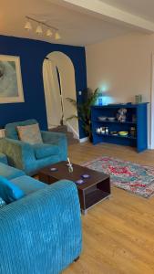 ein Wohnzimmer mit zwei blauen Sofas und einem Tisch in der Unterkunft Riverbank Apartment in Derry Londonderry