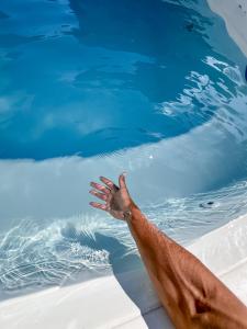 un brazo de persona saliendo de una piscina en Casa Com Piscina - Mongaguá - Disponível Feriado Carnaval, en Mongaguá