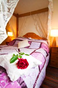 una rosa roja sentada sobre una cama en The Old Wagon House en Saint Clether