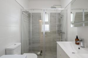 a bathroom with a shower and a toilet and a sink at Sun & Sea Flat Quarteira - by Hopstays in Cavacos +16 photos