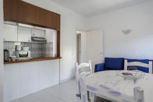 a kitchen and a dining room with a table and chairs at Sun & Sea Flat Quarteira - by Hopstays in Cavacos