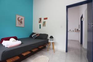 um quarto com uma cama com uma parede azul em Casa Matatiso - casa de 1 quarto na Ilha Grande em Abraão
