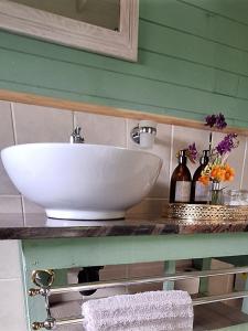 lavabo blanco en la encimera del baño en Cinnamon & Sage Country Cabins, en Dullstroom