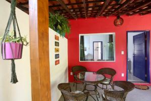 uma mesa e cadeiras num quarto com uma parede vermelha em Casa Matatiso - casa de 1 quarto na Ilha Grande em Abraão