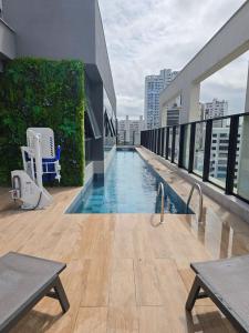 a swimming pool on the roof of a building at A7 Vix by Housi – studios e apartamentos modernos em Vitória in Guajuru