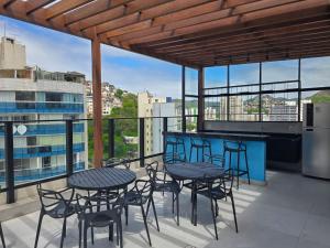 a patio with tables and chairs on a balcony at A7 Vix by Housi – studios e apartamentos modernos em Vitória in Guajuru