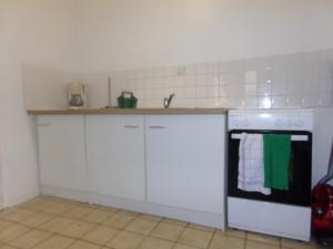 a kitchen with white cabinets and a white stove top oven at Le Goéland in Dieppe +7 photos