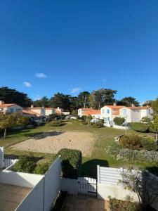 a view of a yard with a white fence and houses at L'Air Marin in Barbâtre