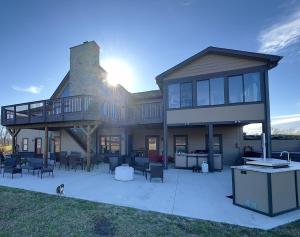 a large house with a patio and a dog in front at Maple Brook Memories in Amanda