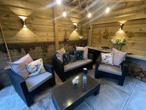 a patio with couches and a table in a room at Riverside 2 Bedroom Townhouse with Car Charger in Abergavenny +15 photos