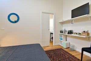 a living room with a table and a tv on a wall at Residenza La Donzella - Appartamento verde in Campobasso