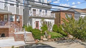 uma casa com uma escada na frente em Quiet Retreat 10 Min to NYC Train & free Parking em Bayonne