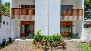 una casa blanca con puertas de madera y plantas en HS Residence 1, en Itacaré