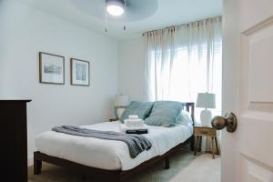 a bedroom with a bed with blue pillows and a window at 4br Modern Getaway - Mins To Ua, King Bed in Maxwell