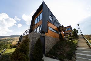 a house on a hill with a black facade at HUUT in Zlatibor