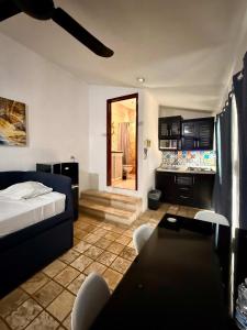 a room with a bed and a table and a couch at Escapada Calida para 4 en Zona Campestre Merida in Chuburná de Hidalgo