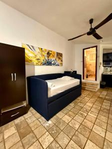 a bedroom with a blue bed and a ceiling fan at Escapada Calida para 4 en Zona Campestre Merida in Chuburná de Hidalgo