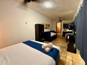 a bedroom with a bed and a living room at Escapada Calida para 4 en Zona Campestre Merida in Chuburná de Hidalgo +8 photos