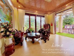 Kon Von KlaにあるHeniSi Homestay Măng Đen Villaのテーブルと椅子と窓のあるリビングルーム