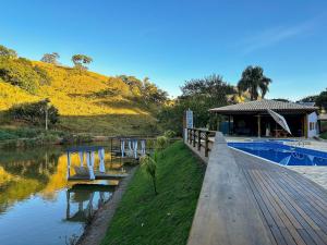 un resort con piscina accanto a un fiume di Rancho Ipês do Lago a Socorro