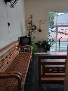 a room with a wooden bench and a television at Edifício thorium in Guarapari