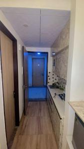 een gang die naar een keuken leidt met een blauwe deur bij Love passion in Greater Noida