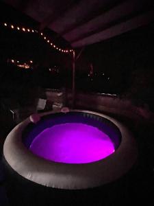 a hot tub with purple light in the dark at Au coin de la cheminée in Saint-Leu