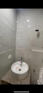 een badkamer met een witte wastafel en een toilet bij Love passion in Greater Noida +7 foto's