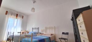 Un dormitorio con dos camas individuales y una cómoda. en Luminoso appartamento nel cuore del Salento, en Campi Salentina