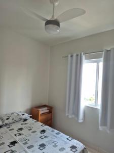 ein Schlafzimmer mit Bett und Deckenventilator in der Unterkunft Apartamento Tennis Prime in Oliveira