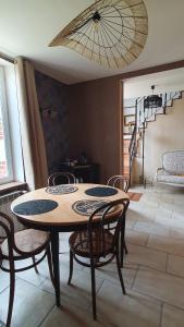 a table and chairs in a room with a staircase at Longère chez Martine et Julie in Romorantin +12 photos