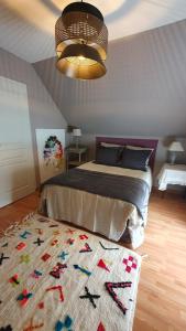 a bedroom with a bed and a rug on the floor at Longère chez Martine et Julie in Romorantin