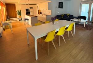 a white table with yellow chairs in a living room at Chez Daniela in Cerva