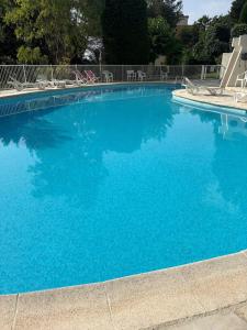 uma grande piscina azul com cadeiras em Le Cocon de Vence - Piscine Free Parking em Vence