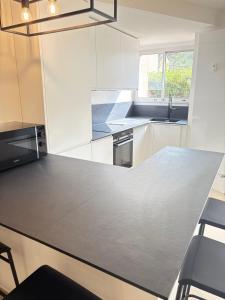 uma cozinha com uma bancada cinza e uma pia em Le Cocon de Vence - Piscine Free Parking em Vence