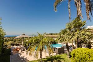 a resort with a swimming pool and palm trees at Dina by Vintage Travel in Kaligata