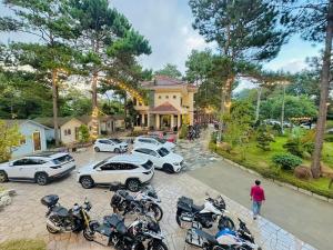 Kon Von KlaにあるHeniSi Homestay Măng Đen Villaの家の前に駐車された車とバイクの群れ +10枚の写真