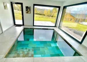 una habitación con suelo de cristal y dos ventanas en O'Cocoon, en Fraize
