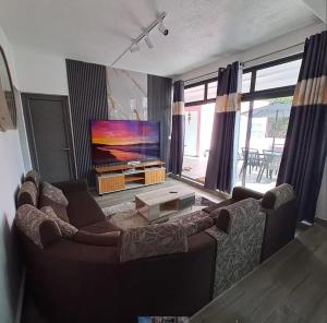a living room with a couch and a flat screen tv at Charming Villa with Pool in Souillac in Souillac