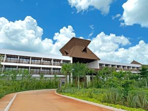 a building with a roof on the side of a road at Hotel Mundo Maya Nuevo Uxmal in Santa Elena