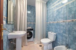 a bathroom with a white toilet and a sink at El Rincón de Doñana in Villamanrique de la Condesa +11 photos