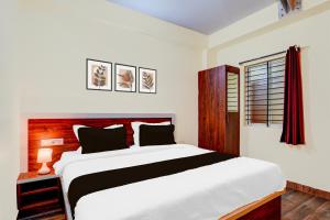 a bedroom with a large white bed and a window at HOTEL O UTSAV STAY in Jālahalli