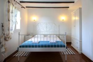 a bedroom with a white bed with a blue blanket at Melodia in Fternón