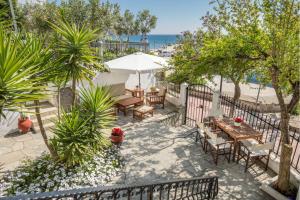 an outdoor patio with tables and chairs and the beach at D&D Holiday Studios in Potos